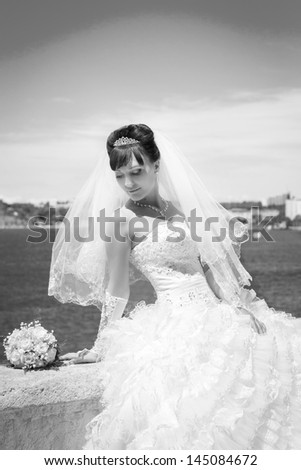 Beautiful Happy bride with wedding flowers bouquet in white dress with wedding hairstyle and makeup. Smiling woman in wedding dress waiting for groom. Pretty brunette girl bride. Jewelry and Beauty