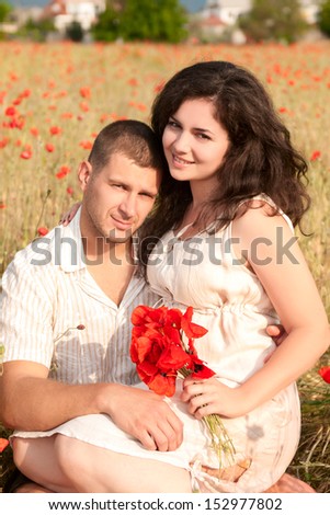 couple in love enjoy a moment of happiness in blossom spring garden with field flowers on nature. handsome young man and beautiful brunette girl happy. Loving couple on date in park looking happy