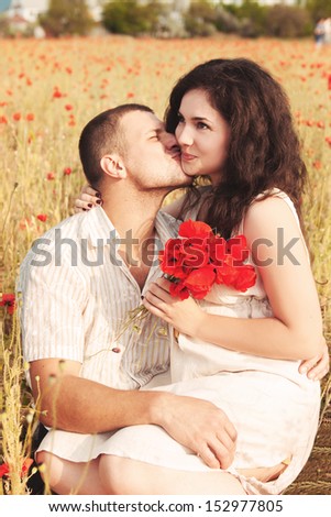 couple in love enjoy a moment of happiness in blossom spring garden with field flowers on nature. handsome young man and beautiful brunette girl happy. Loving couple on date in park looking happy