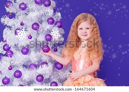 Christmas kid girl  near Christmas tree with gifts. New year winter party. Happy small girl in santa  with present have a christmas.