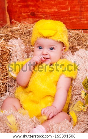 Funny lovely baby  little child in Easter basket with eggs in chicken costume. Easter holiday concept: nest with baby chick
