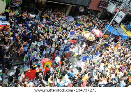 BANGKOK - APRIL 13: Unidentified people have a water fight on Songkran Day, April 13, 2013 at Silom Road in Bangkok. Water fights are a popular way to celebrate Songkran Day.