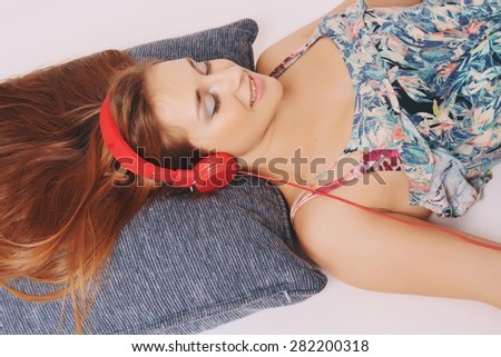 Young girl lying on the floor with red headphones