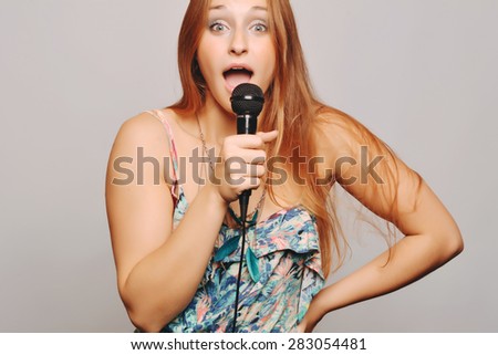 Beautiful blonde woman singing with microphone. Music concept