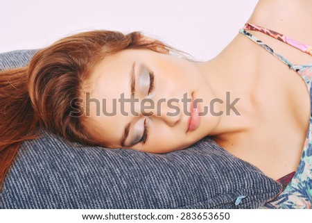 Beautiful young woman sleeping with her head over a pillow