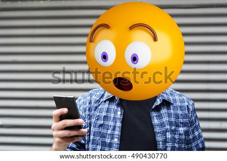 Surprise emoji head man using a smartphone. Emoji concept