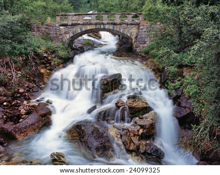 Old stone bridge over small stream water