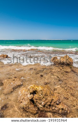 Beautiful azure red sea with waves and rocks and clear blue sky in Egypt