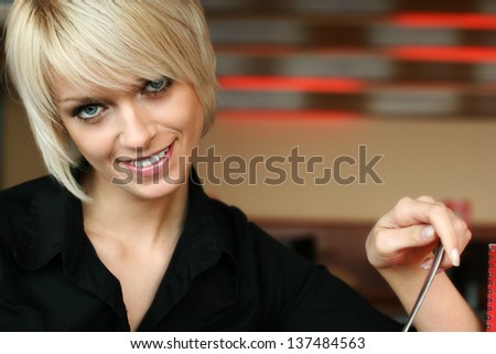 Portrait of a young blond woman with a gentle smile and trendy modern short hairstyle with copy space