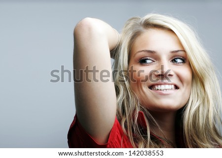 Studio shot of beautiful Caucasian female model posing with one arm behind her head, isolated on white background.