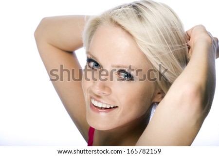 Smiling happy woman with short blond hair raising her hands behind her head as she smiles at the camera, closeup head shot isolated on white
