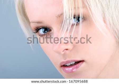 Close up face portrait of a beautiful young woman with a curious searching look staring intently at the camera with parted lips