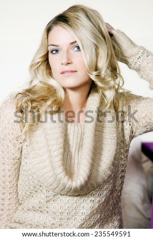 Half Body Shot of Pretty Young Blond Woman Posing in Elegant Off White Long Sleeve Top While Looking at the Camera.