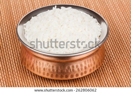 Cooked rice served in authentic copper bowl.