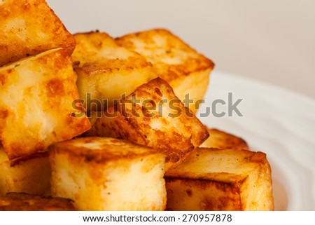 Macro closeup image of delicious ghee fried Indian paneer (cottage cheese) cubes on a plate. Shallow Depth of field.