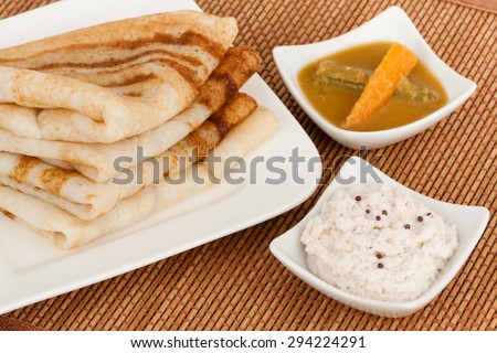 A traditional ethnic south Indian breakfast of Dosa (Dosai) stack served with coconut chutney and sambar.