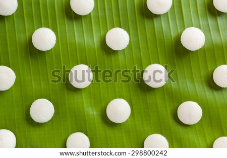 Fresh Indian mini idly - Fresh steamed Indian mini Idly (Idli / rice cake) arranged decoratively on traditional banana leaf. Can also be used as food backgrounds. Natural light used.