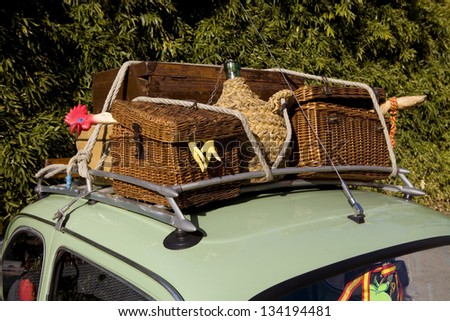 Old and funny wicker suitcases. Funny vintage baggage on the roof of an old car