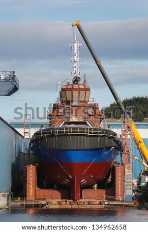 Boat in a Shipyard. Ship under construction and crane in a shipyard. Cantabric Sea Coast, Spain.