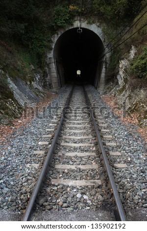 Railway tunnel. Railroad track entering in a dark tunnel