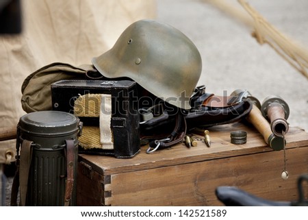 Antique helmet and other military  equipment over a wooden box.  Military equipment.