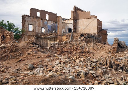 View of an old ruined house over a pile of rubble. House in ruins.