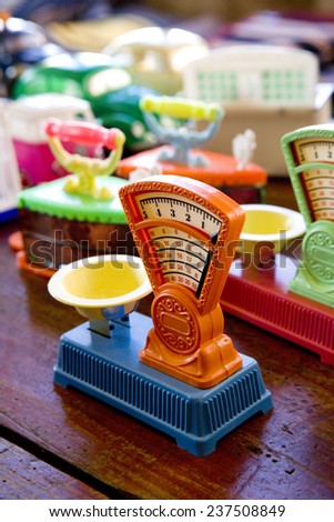 A few multi colored plastic weight scales in a toy store.  Toy Weight Scale.