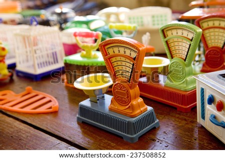 A few multi colored plastic weight scales in a toy store.  Toy Weight Scale.