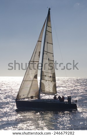 Vertical back-lighting view of a sailboat on the sea . Sailboat.