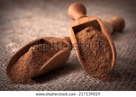ground cinnamon spice powder in wooden spoon