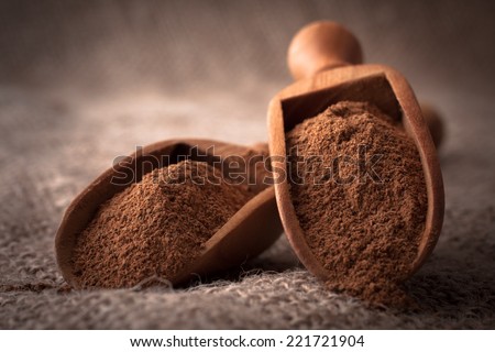 ground cinnamon spice powder in wooden spoon
