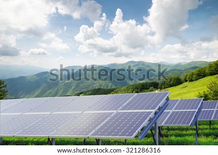 solar panels against mountain landscape against blue sky with clouds