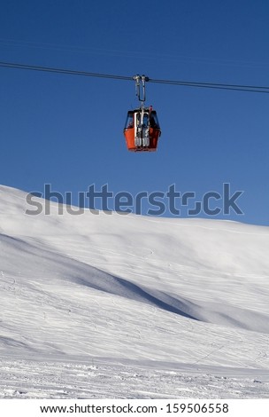 MÃ?Â¤nnlichen bahn, a gondola lift bringing skiers into the mountains at Grindelwald  (Eiger / Jungfrau area), Berner Oberland, Switzerland. Red gondola against blue sky.