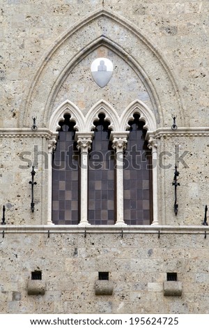 The typical three-part Sienese gothic windows of Palazzo Salimbeni, the 14th century headquarters of the world\'s oldest bank: Monte dei Paschi di Siena. Siena, Italy.