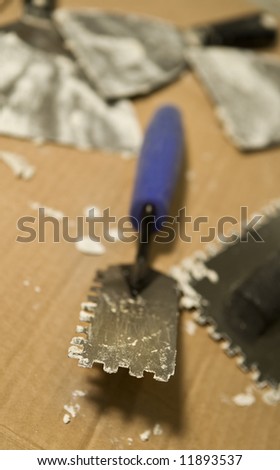 Extreme selective focus view of a tile setting trowel for tile setting.