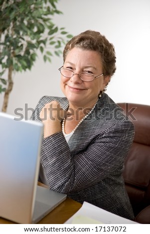 Pleasant senior executive woman at her desk