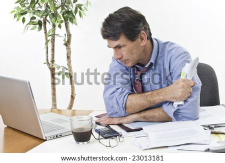 Stressed businessman at his office laptop, trying to find the best direction for his company.