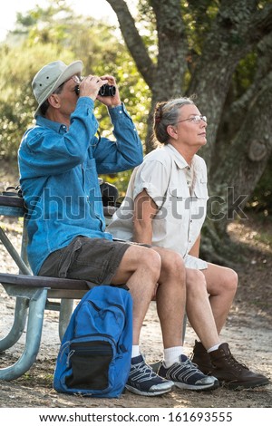 http://image.shutterstock.com/display_pic_with_logo/153007/161693555/stock-photo-happy-mature-man-and-woman-resting-at-a-picnic-table-at-a-campsite-watching-birds-with-binoculars-161693555.jpg