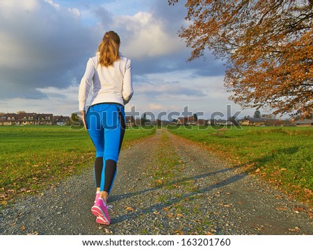 Female running in nature on a long road