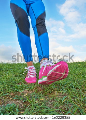 Female legs coming down the hill with pretty background clouds