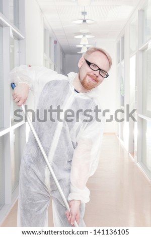 Man in Overall Cleaning Office Corridor with Smile