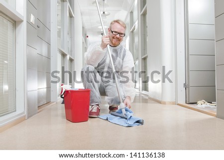 Man in Overall Cleaning Office Corridor