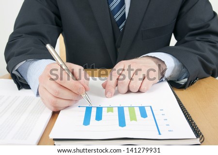 Man in Suite Working on Graph