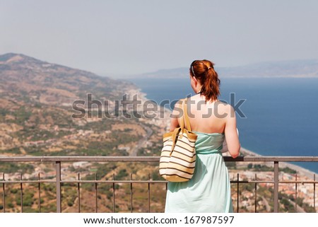Young Woman Looking Down From High Lookout, Focus on Viewer