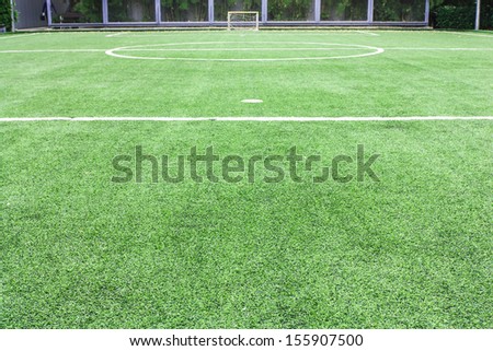 Empty soccer field with goal with green plastic glasses