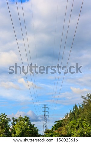 Tower for electricity in rural landscape under blue sky