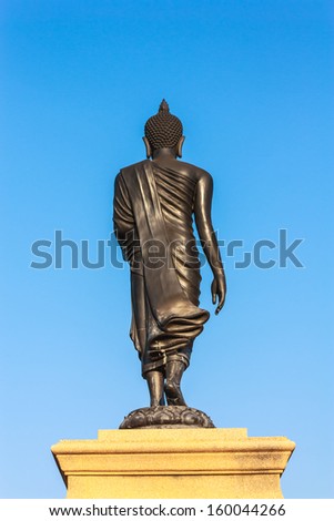 Back of walking Buddha statue with white background