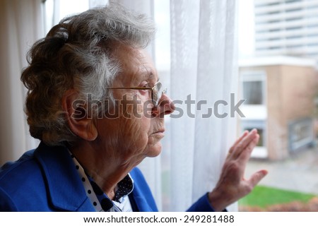 Elderly woman looking out a window