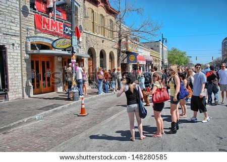 AUSTIN, TX - MAR 14: Tourists enjoy SXSW festival in city streets, March 14 2008 in Austin. SXSW began in 1987, and has continued to grow in size every year.