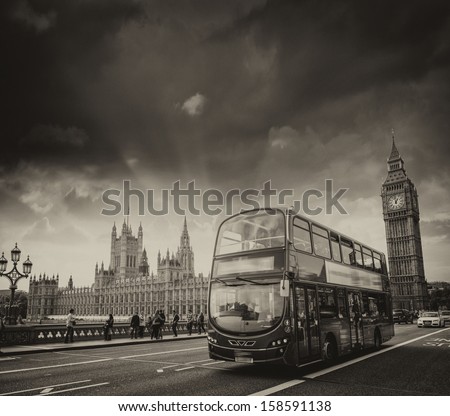 London. Classic red double decker bus crossing Westminster Bridge at sunset.